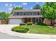 Charming two-story home with a brick facade, manicured lawn, and attached two-car garage at 7312 S Moore Ct, Littleton, CO 80127
