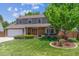 Traditional two-story home with brick accents, mature tree, and well-maintained front lawn at 7312 S Moore Ct, Littleton, CO 80127