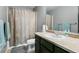 Bathroom features a tub with shower curtain, a vanity, and a mirror at 9919 Memphis St, Commerce City, CO 80022