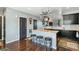 Well-lit kitchen boasts modern dark cabinets, an island with seating and pendant pot rack at 9919 Memphis St, Commerce City, CO 80022