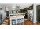 Open kitchen features dark cabinetry, stainless steel appliances, and a functional island with seating at 9919 Memphis St, Commerce City, CO 80022