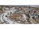 Wide aerial view of a neighborhood showcasing backyards with snow-covered landscaping and nearby roads at 26531 E Calhoun Pl, Aurora, CO 80016