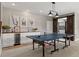 Finished basement featuring a stylish bar, ample storage, and a recreation area with a ping pong table at 26531 E Calhoun Pl, Aurora, CO 80016