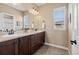 Stylish bathroom featuring a double vanity, elegant mirrors, and natural light from the window at 26531 E Calhoun Pl, Aurora, CO 80016