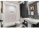 Modern bathroom with subway tile shower, floating vanity, and contrasting dark gray accent wall at 26531 E Calhoun Pl, Aurora, CO 80016