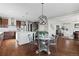 Bright dining area featuring wood floors and a modern light fixture, adjacent to the kitchen and living room at 26531 E Calhoun Pl, Aurora, CO 80016