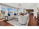 Sun-filled living room featuring hardwood floors, stylish furnishings, and large windows with neighborhood views at 26531 E Calhoun Pl, Aurora, CO 80016