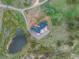 Aerial of property with modern home, pond, and a curved driveway surrounded by natural landscape at 28098 Green Valley Ln, Conifer, CO 80433