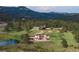 Estate with modern home, pond, outbuildings, trees, lush grounds, and mountain backdrop at 28098 Green Valley Ln, Conifer, CO 80433