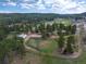 Aerial view of forested area with home, outbuildings, and meadow at 28098 Green Valley Ln, Conifer, CO 80433