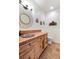 A rustic bathroom has a decorative mirror, tiled counter, and earth-tone fixtures at 28098 Green Valley Ln, Conifer, CO 80433