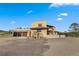 Tan two-story home with a three-car garage, tile roof, and mature landscaping at 28098 Green Valley Ln, Conifer, CO 80433
