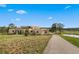 Tan two-story home with mature landscaping, trees, and mountain views on a sunny day at 28098 Green Valley Ln, Conifer, CO 80433