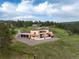 Aerial view of stucco house with three car garage on a grassy hillside at 28098 Green Valley Ln, Conifer, CO 80433