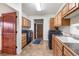 A functional laundry room features modern appliances, wooden cabinets and sink at 28098 Green Valley Ln, Conifer, CO 80433
