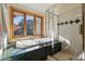 Modern bathroom with a soaking tub under large windows and a glass-enclosed shower at 9041 Eastridge Rd, Golden, CO 80403