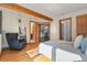 Bedroom with hardwood floors, a cozy chair, and a view into the bathroom and office at 9041 Eastridge Rd, Golden, CO 80403