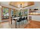 Elegant dining area features a wood ceiling, modern chandelier, and large windows overlooking the surrounding landscape at 9041 Eastridge Rd, Golden, CO 80403
