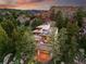 Stunning aerial view of a luxury home nestled amongst trees and rock formations at sunset at 9041 Eastridge Rd, Golden, CO 80403