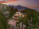 Scenic view of a modern home with a driveway nestled amongst lush trees and dramatic rock formations at 9041 Eastridge Rd, Golden, CO 80403