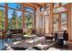 Cozy living room featuring wood ceilings, many windows, and leather furniture at 9041 Eastridge Rd, Golden, CO 80403