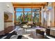 Spacious living area with large windows showcasing the scenic views and wood beam ceilings at 9041 Eastridge Rd, Golden, CO 80403