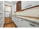 Well-organized pantry with white cabinets, tile countertops, and convenient access to the laundry area with washer and dryer at 9041 Eastridge Rd, Golden, CO 80403