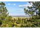 Breathtaking view showcasing lush greenery, rolling hills, and a serene sky with scattered clouds at 9041 Eastridge Rd, Golden, CO 80403