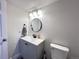 Cozy bathroom with modern lighting, round mirror, and a stylish vanity sink and toilet at 5724 S Rome St, Aurora, CO 80015