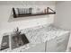 Stylish wet bar area featuring a stainless steel sink, granite countertop, modern cabinetry, and shelving at 5724 S Rome St, Aurora, CO 80015