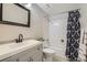 This bathroom features white tile, gray cabinets, and a bath tub at 9630 W 104Th Ave, Broomfield, CO 80021