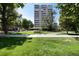 A high rise apartment building is nestled in a lush green park-like setting at 1200 N Humboldt St # 1103, Denver, CO 80218