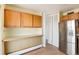 View of kitchen with wood cabinets, stainless steel refrigerator, and pantry at 1200 N Humboldt St # 1103, Denver, CO 80218