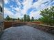 Wide view of a concrete backyard patio area with beautiful stone retaining wall and wooden perimeter fence at 483 W 172Nd Pl, Broomfield, CO 80023