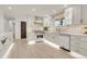 Stylish kitchen boasts white cabinetry, modern appliances, gold hardware, and light wood flooring at 3281 Vivian Dr, Wheat Ridge, CO 80033