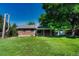Brick home with a spacious backyard, covered patio, and mature trees at 7479 Pierce St, Arvada, CO 80003