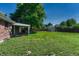 Large backyard with a wooden fence, mature trees, and ample space for activities at 7479 Pierce St, Arvada, CO 80003