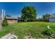 Expansive backyard featuring lush lawn, mature trees, and partial shed view at 7479 Pierce St, Arvada, CO 80003