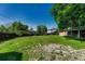 Expansive backyard with mature trees, wooden fence, and lawn at 7479 Pierce St, Arvada, CO 80003