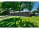 A single-Gathering brick house boasting a lush green lawn, framed by mature trees and a clear, sunny sky at 7479 Pierce St, Arvada, CO 80003