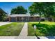 Quaint brick house with a well-kept lawn, sidewalk, and mature trees in a sunny neighborhood setting at 7479 Pierce St, Arvada, CO 80003