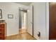 This hallway features laminate flooring and a view into the bathroom with shower and tub at 7479 Pierce St, Arvada, CO 80003