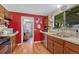 Cozy kitchen features wood cabinets, stainless steel dishwasher, and a window overlooking the yard at 7479 Pierce St, Arvada, CO 80003