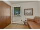 This living room features wood look vinyl flooring, a window, and a comfortable brown leather sofa at 7479 Pierce St, Arvada, CO 80003