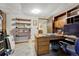 Home office featuring a built-in desk, floating shelves, and an open doorway to additional space at 7479 Pierce St, Arvada, CO 80003