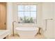 Modern bathroom with a stand-alone soaking tub and a large window at 20 Viking Dr, Cherry Hills Village, CO 80113
