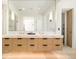 Modern bathroom with double vanity, stone floors, and a large mirror at 20 Viking Dr, Cherry Hills Village, CO 80113