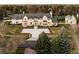 Stunning white home with a large yard and a circular driveway, surrounded by lush trees and landscaping at 20 Viking Dr, Cherry Hills Village, CO 80113