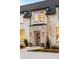 Close-up of front door with stone trim, planter boxes, and a well manicured yard at 20 Viking Dr, Cherry Hills Village, CO 80113