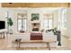 Bright living room with fireplace, wood beams, light wood floors, and many windows at 20 Viking Dr, Cherry Hills Village, CO 80113